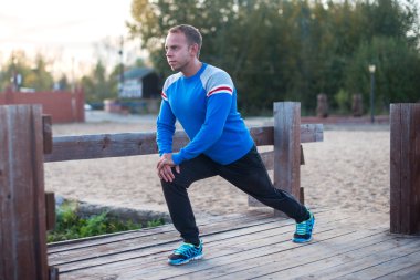 spor adamı yapıyor aoutdoors germe akşam günbatımında uygular. Fitness kavramları