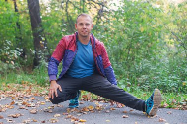 spor adamı park sonbahar germe egzersizleri yapıyor. Fitness kavramları