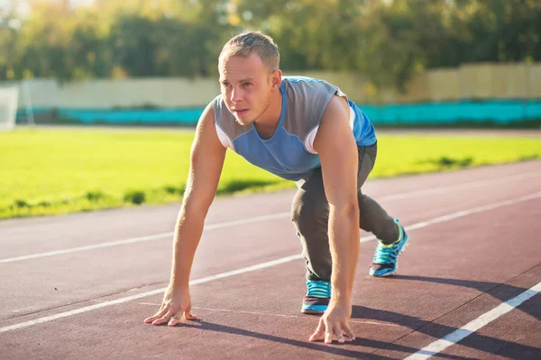 Hombre atlético de pie en postura listo para correr en una cinta de correr — Foto de Stock