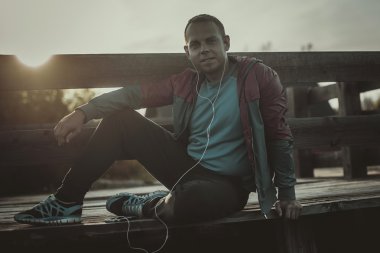 oturma, dinlenme ve ahşap bir iskele, spor üstünde senin telefon müzik yorgun runner.