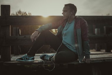 oturma, dinlenme ve ahşap bir iskele, spor üstünde senin telefon müzik yorgun runner.