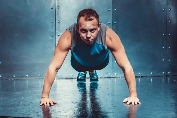 Hombre atlético entrena, empujado hacia adelante mirando. concepto de salud y fuerza — Foto de Stock
