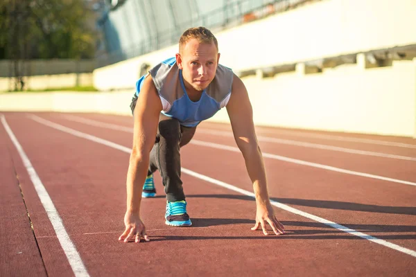 Hombre atlético de pie en postura listo para correr en una cinta de correr . — Foto de Stock