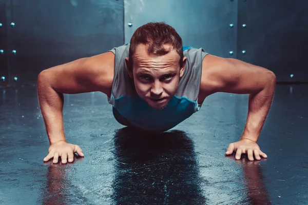 Hombre atlético entrena, empujado hacia adelante mirando. concepto de salud y fuerza . — Foto de Stock