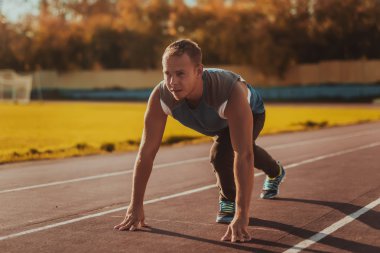 Atletik adam ayakta duruş bir koşu bandı üzerinde çalışmaya hazır