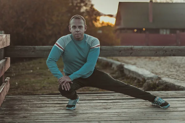 Spor adamı yapıyor aoutdoors germe akşam günbatımında uygular. Fitness kavramları. — Stok fotoğraf