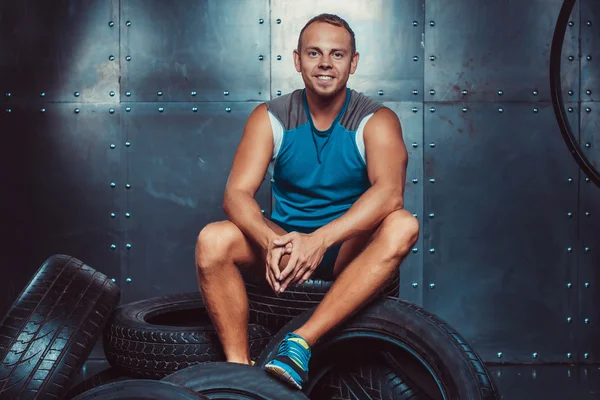 Deportista sentado en la máquina de neumáticos. Concepto de CrossFit, salud y fuerza . — Foto de Stock