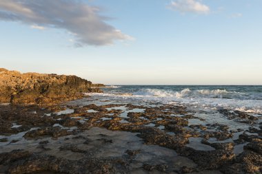 Kayalık sahil. Günbatımı denize