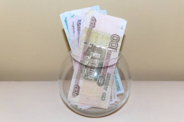 Cam bir kavanozda çeşitli değerlerde Rus rublesi banknotları.