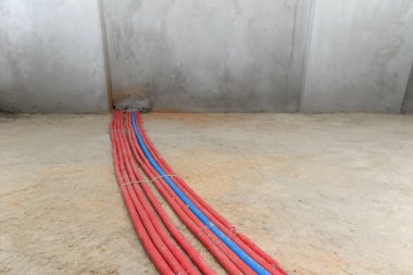 Yeni binanın zemininde kırmızı ve mavi borular ısıtılıyor.