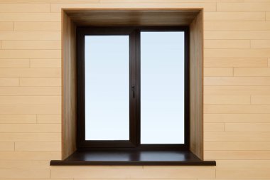 Odanın içi aydınlık ahşap ve karanlık bir pencereyle kaplı.