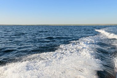 Bir yaz günü denizin yüzeyindeki teknenin uyanışı.