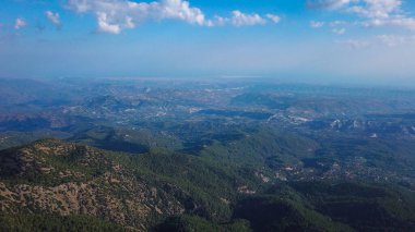 Troodos dağlarının eteklerindeki yeşil tepelerin havadan görünüşü, İHA ile Kıbrıs fotoğrafı