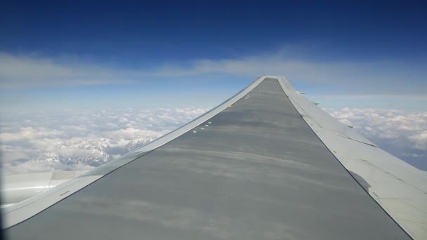 Ver elyuminatory volando un avión de pasajeros sobre las montañas en las nubes — Vídeos de Stock