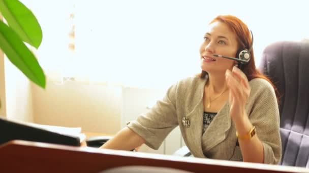 Centro de Atención al Cliente. Operadora hablando con el cliente a través de auriculares — Vídeos de Stock