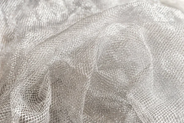abstract background of silver mesh fabric close up