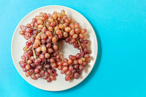 Racimo Uvas Jugosas Maduras Plato Sobre Una Superficie Azul — Foto de Stock