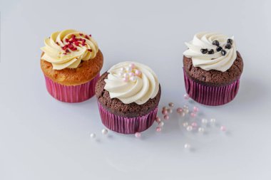 Onlar için açık cam bir yüzey üzerinde çeşitli kap kekler ve dekorlar yakın.