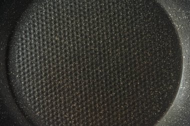 Kızartma tavasının yüzeyinin soyut arkaplanı ve yakın bir taş kaplama.