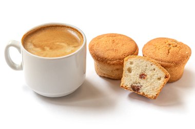 Kuru üzümlü ev yapımı mini kekler ve beyaz yüzeyde bir fincan kahve.