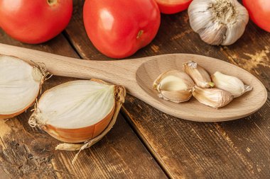 Tahta bir masada domates, soğan ve sarımsak.