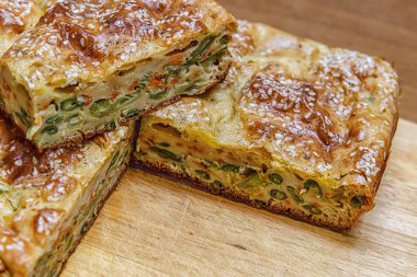 Tahta üzerinde sebzeli ve yeşil fasulyeli ev yapımı turta.