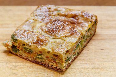 Tahta üzerinde sebzeli ve yeşil fasulyeli ev yapımı turta.