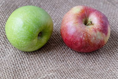 olgun sulu kırmızı ve yeşil elmalar çuval bezi üzerinde yakın