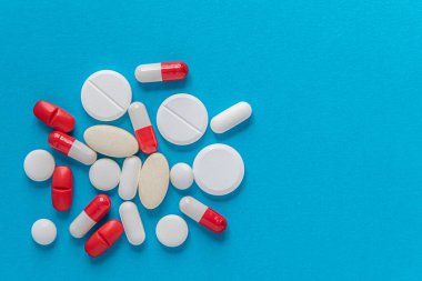  Mavi bir yüzey, üst görünüm, kopya alanı, ilaç, sağlık, tedavi, eczane konsepti üzerindeki çeşitli tabletlerin, hapların ve kapsüllerin tıbbi geçmişi