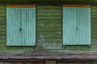 Terk edilmiş ahşap bir binanın pencereleri.