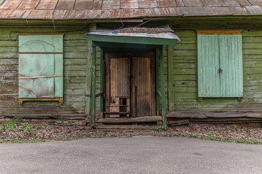 Kapıları ve pencereleri tıkalı terk edilmiş eski ahşap bir ev.