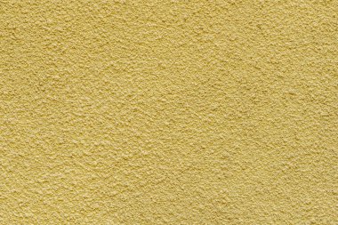 Kabartmalı eski bir duvarın soyut arkaplanı sarıya boyanmış.