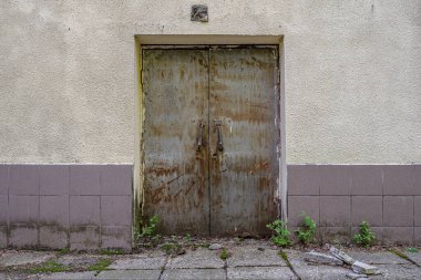 Paslı metal kapıları olan eski bir duvarın soyut arka planı