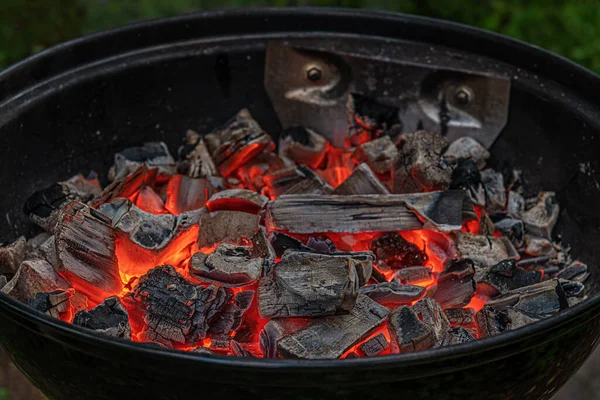 smoldering embers in a grill in the backyard, preparation for barbecue