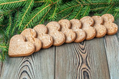 Noel şenliği ve yeni yıl arkaplanı. Fotokopi alanı, köknar dalları ve eski ahşap bir masada zencefilli kurabiye. 