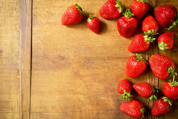 Rijpe aardbeien op een rustieke tafel — Stockfoto