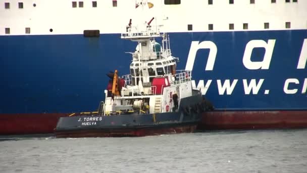 Rebocador espanhol ajudando um navio de carga geral para atracar — Vídeo de Stock