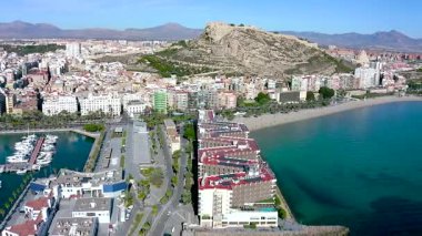 Santa Barbara Kalesi 'nin havadan görünüşü ve İspanya' nın Akdeniz kenti Alicante 'deki Postiguet Sahili' nin yanındaki ilk binalar..
