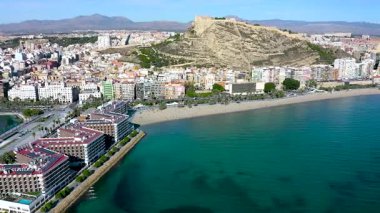 Santa Barbara Kalesi 'nin havadan görünüşü ve İspanya' nın Akdeniz kenti Alicante 'deki Postiguet Sahili' nin yanındaki ilk binalar..