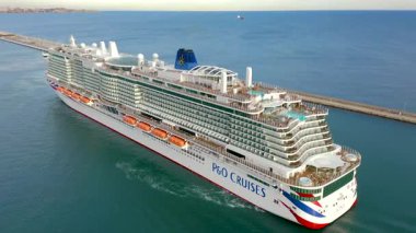 ALICANTE, İSPAN 24 Haziran 2025. İspanya 'nın Akdeniz kıyısındaki Alicante limanından ayrılmak için manevra yapan büyük yolcu gemisi IONA' nın hava görüntüsü..