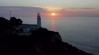 İspanya, Alicante 'deki La Nao Burnu' nun deniz fenerinde, deniz ufkunun üzerinde güzel bir gün doğumunun hava görüntüsü..