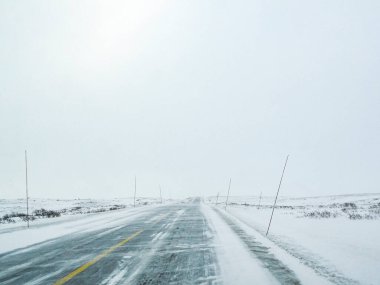 Norveç 'te kar fırtınası, kara buz ve karlı beyaz yol ve arazide yol alırken.
