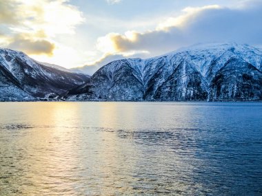 Norveç 'in Vestland kentindeki Sognefjord' da kış manzarası ve sabah güneşi doğuyor..