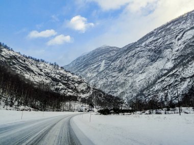 Norveç 'in karlı beyaz yolu ve kış manzarası boyunca sürüyorum..