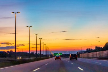 Renkli bir gündoğumunda ya da günbatımında İsveç 'te araba sürmek.