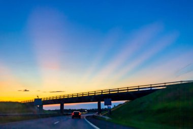 Renkli bir gündoğumunda ya da günbatımında İsveç 'te araba sürmek.