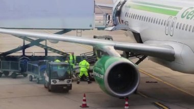 Havaalanı penceresi. Germania Havayolları uçağı yolcu köprüsüne yanaşıyor..