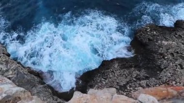 Kayalıklardan aşağıya Mallorca İspanya 'nın aşırı dalgalarına bakıyorum..