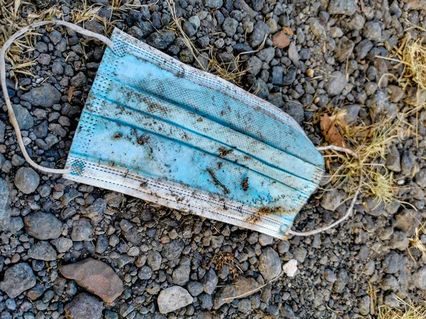 Dirty surgical blue masks on the ground. Corona virus pollution. Covid19.
