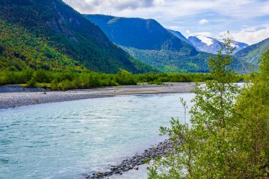Turkuaz eriyen su, Norveç 'in güzel dağlarından akan bir nehirde akıyor..